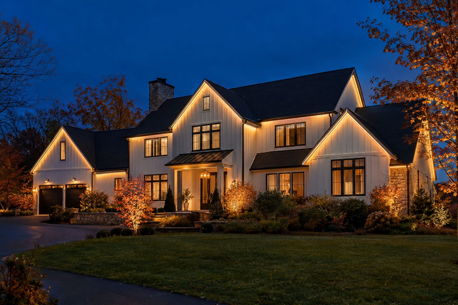 White farmhouse at dusk with permanent LED lights glowing warm white along the rooflines and gables